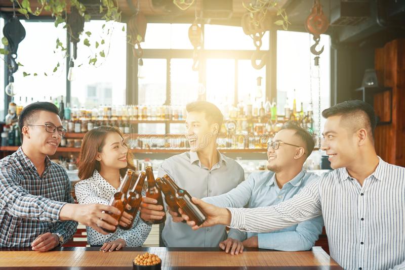 group-happy-asian-men-women-gathering-together-modern-sunny-bar-toasting-beer-bottles-cheerful-ethnic-people-123903101